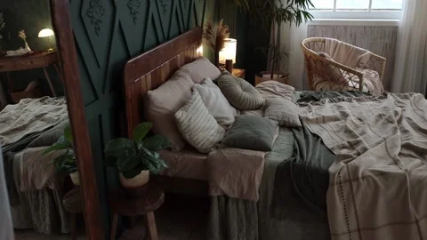 Cozy bedroom interior in boho style with green walls, wooden furniture, console Stock Footage 233765031