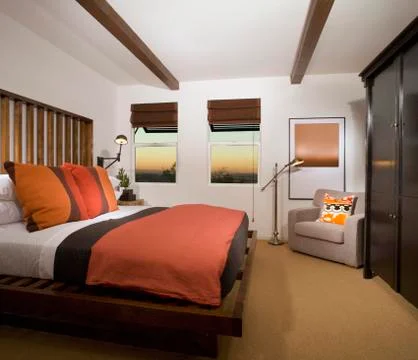 Cozy Bedroom with Terra Cotta Colored Comforter Stock Photos
