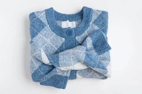 Cozy blue argyle pattern knitted cardigan with button detail folded neatly .. Stock Photos