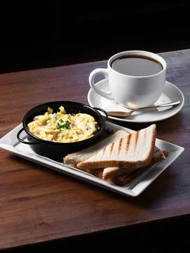 Cozy breakfast features scrambled eggs and toasted bread Stock Photos
