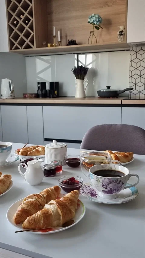 Cozy breakfast table with croissants and coffee in modern kitchen. Stock Footage 339909854