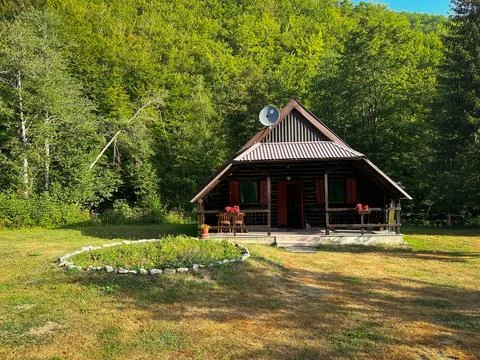 Cozy cabin in the forest in the mountains from the log log on a bright sunny day Stock Photos
