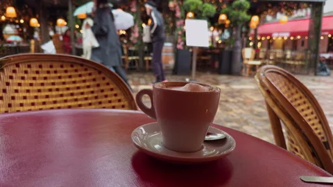 A cozy cafe scene featuring a steaming coffee cup while people stroll about Stock Footage 318554558
