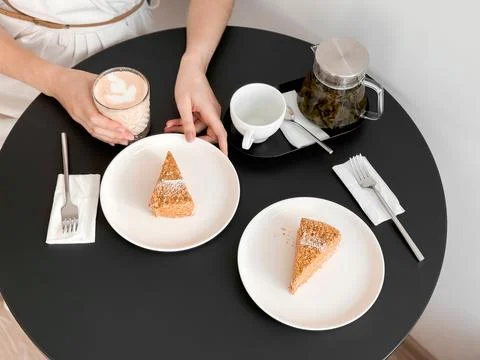 Cozy cafe setting with tea and cake slices on a round table Foto stock