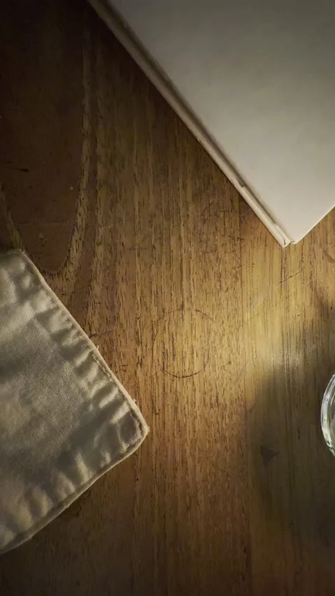 Cozy Candlelight Table Scene with Book and Linen Cloth on Wooden Surface Stock Footage 332543111