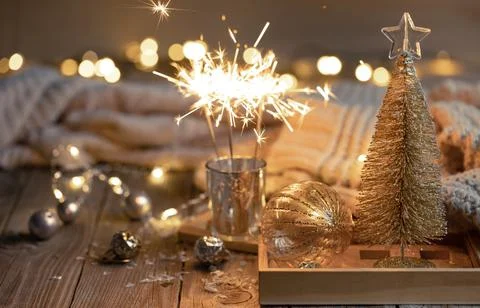 Cozy Christmas background with glowing sparklers and decor details. Stock Photos