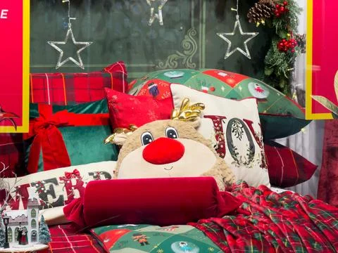 Cozy Christmas bedding ensemble featuring plush reindeer, festive pillows w.. Stock Photos