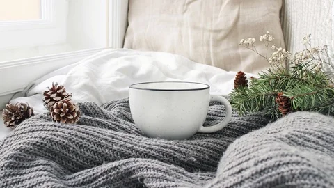 Thermos with a steaming mug of hot drink stands in the snow