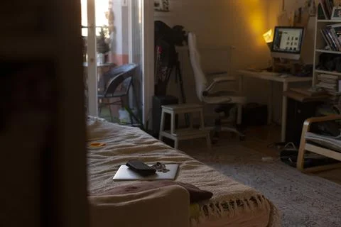 Cozy coding session. Dimly illuminated desk with glowing screen and clutter Stock Photos