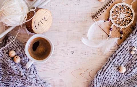 Cozy composition with coffee, knitted elements from merino wool on a wooden b Stock Photos
