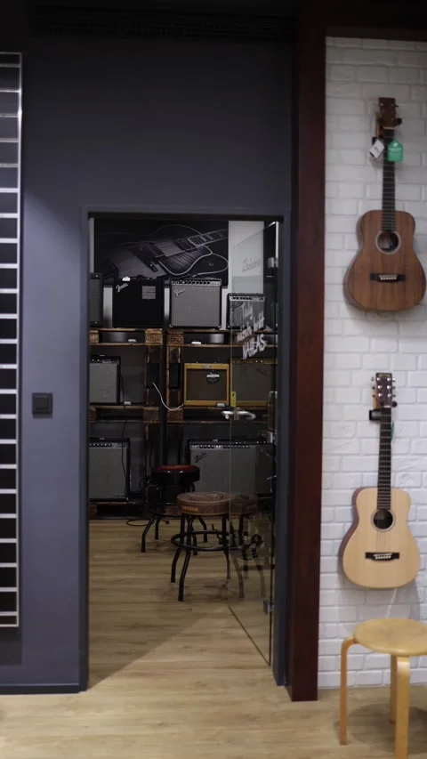 A cozy corner of a music store showcasing a variety of guitar amplifiers on shel Stock Footage 294702760