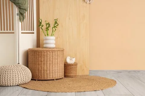 Cozy corner with natural decor elements, wicker basket, lucky bamboo, and rou Stock Photos