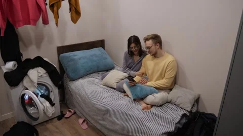 Cozy couple watching smartphone in bed Stockbeeldmateriaal 336533718