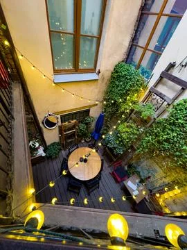 Cozy Courtyard Cafe with String Lights and Greenery Stock Photos