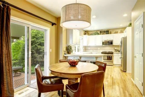 Cozy dining area with round table and leather chairs Stock Photos