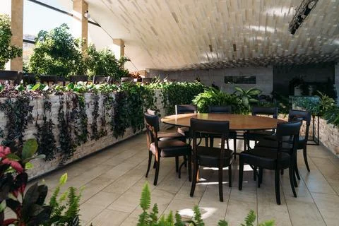 Cozy dining area surrounded by lush plants in a modern interior space showcasing Stock Photos