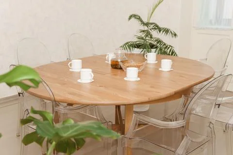 Cozy dining setting featuring a round wooden table surrounded by transparent Stock Photos