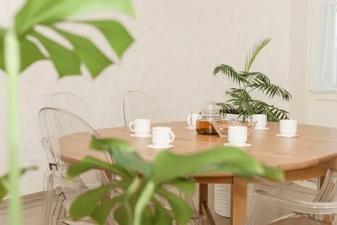 Cozy dining setting featuring a round wooden table surrounded by transparent Stock Photos