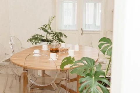 Cozy dining setting featuring a round wooden table surrounded by transparent Foto stock
