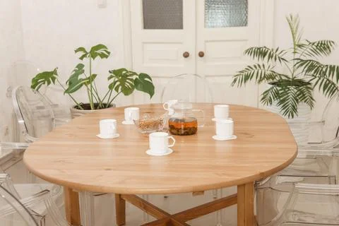 Cozy dining setting featuring a round wooden table surrounded by transparent Foto stock