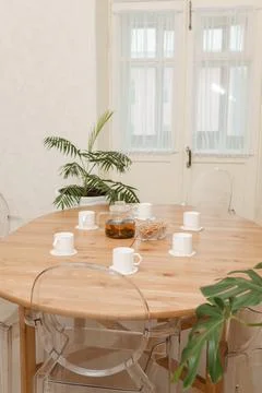 Cozy dining setting featuring a round wooden table surrounded by transparent Stock Photos