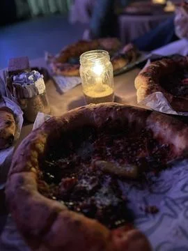 Cozy Dining Table with Deep-Dish Pizzas and Candlelight Stock Photos
