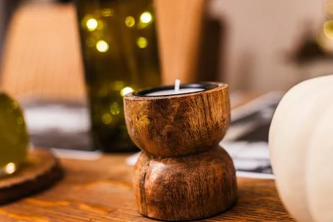Cozy dining table featuring a rustic wooden candle holder and decorative Stock Photos