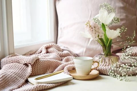 Cozy Easter, spring still life scene. Cup of coffee, opened notebook, pink Stockfoto's