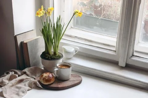 Cozy Easter spring still life scene. Cup of coffee, sweet bun, books, wooden Fotos Stock