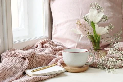 Cozy Easter, spring still life scene. Cup of coffee, notebook, golden pen, pink Foto stock