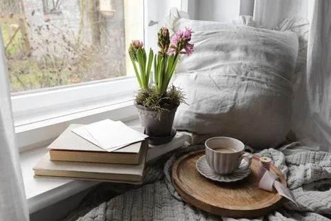 Cozy Easter, spring still life scene. Cup of coffee, books and blank greeting Stock-Fotos