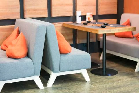 Cozy empty table and soft sofas with pads in a cafe Stock Photos