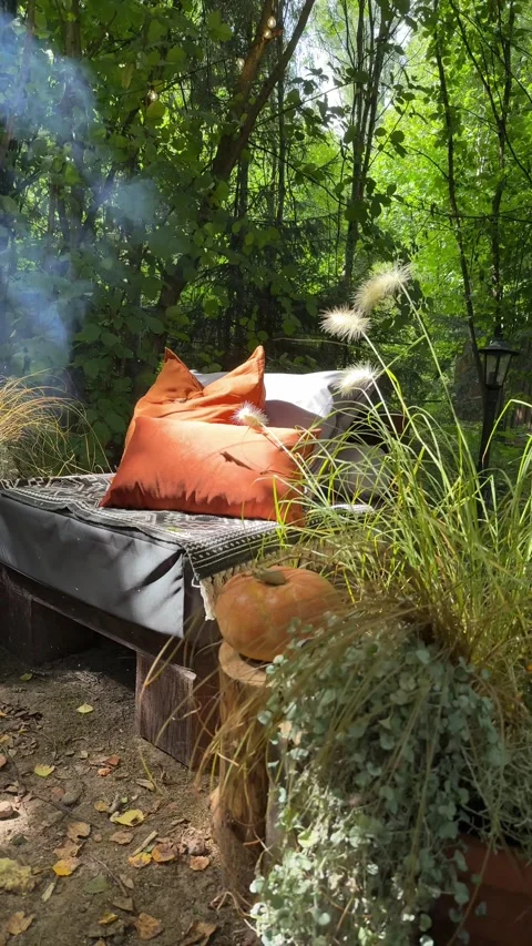 Cozy fall outdoor lounge with pumpkin decor in woodland garden Video stock 342648437