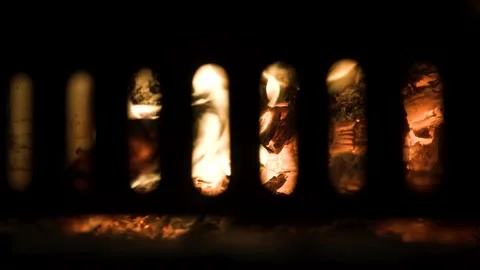 Cozy Fire Burning Inside Wood Stove Through Metal Grate Stock Footage 314839346