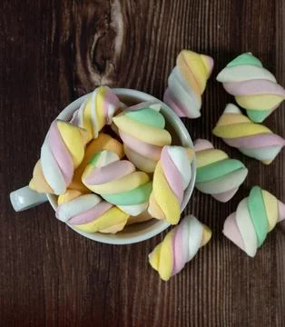 Cozy flat lay background template with a cup of colorful marshmallows and s.. Stock Photos