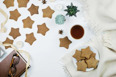 Cozy flatlay with cup of tea of coffee, book, star shaped gingerbread cookies Stock Photos