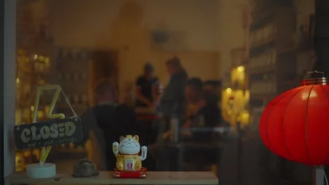 Cozy gathering inside a traditional eatery on a quiet evening with signboard Stock Footage 296188432