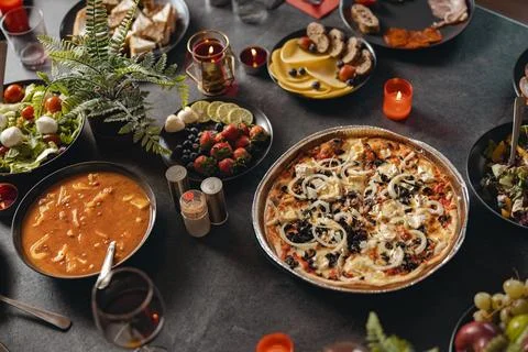 Cozy holiday table setting with different delicious food and beverages ready for Foto stock