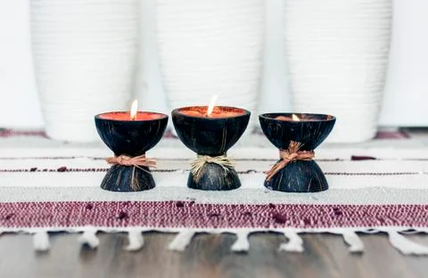 Cozy home interior decor background, burning candles in coconut shell on a mu Stock Photos