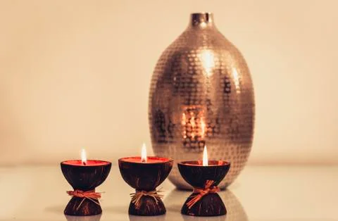 Cozy home interior decor, burning candles on the background of a metal vase . Stock Photos