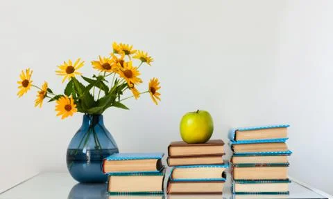 Cozy home interior decor: stack of books and vase with yellow flowers on a ta Stock Photos