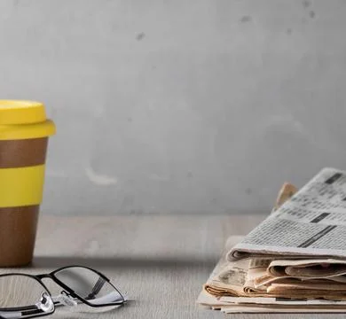 Cozy home scene - a stack of old read newspapers, glasses and a glass of coffee Foto stock