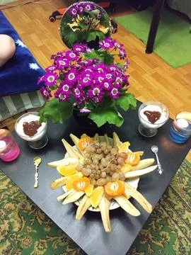 Cozy Indoor Table Setting with Fruit and Flowers Stock Photos