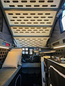 Cozy interior design of a custom overland truck camper with pop-up roof. Stock Photos