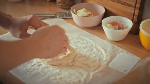 In cozy kitchen man takes on culinary role skillfully kneading homemade pizz Stock Footage 331866619