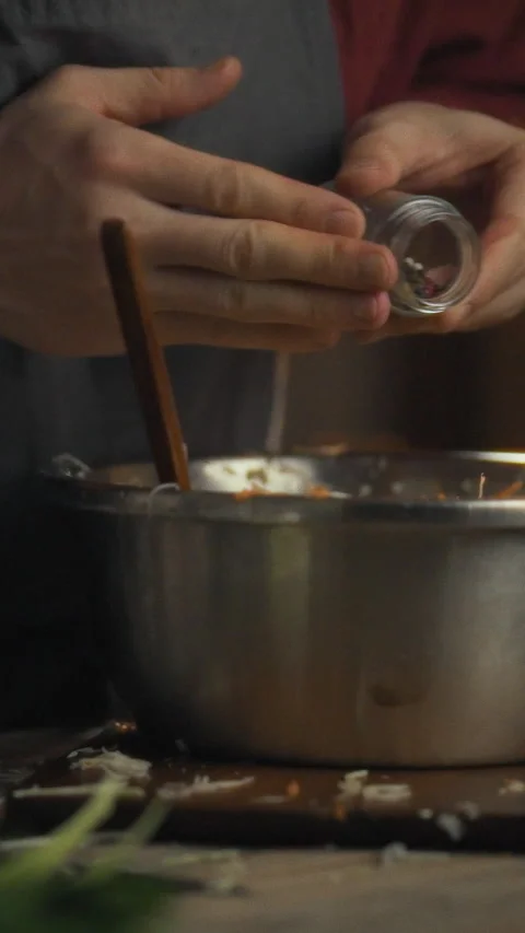 In a cozy kitchen a skilled chef prepares a nutritious meal by adding pepper Stock Footage 334397883