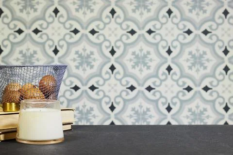 Cozy Kitchen Still Life With eggs in Wire Basket, Candle and Books Against Patte Stock Photos