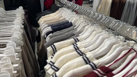 Cozy Knitted Sweaters and Cardigans Hanging on Store Hangers Stock Footage 317537606