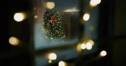 Cozy living room with fireplace, lights and Christmas tree viewed from window. Stock Footage