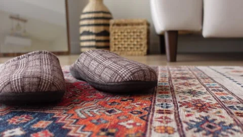 A cozy living room with soft slippers and a vintage rug, inviting warmth Video stock 296291153